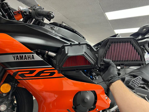 Technician evaluating OEM motorcycle parts during an insurance collision accident crash assessment at Motorcycle Doctors workshop in Auckland